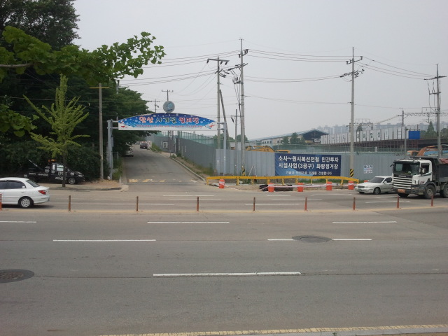 Nearing the next station, Gongdan (공단) Station, at (4) on the Google map in this article. Everything is changing here because of the new connecting line, which will run from left to right in this picture, the new station, Choji (초지), will be to the right of Gongdan Station. In the distance is the present day Gongdan Station. All tracks are gone, they used to run straight through what is now a construction site.